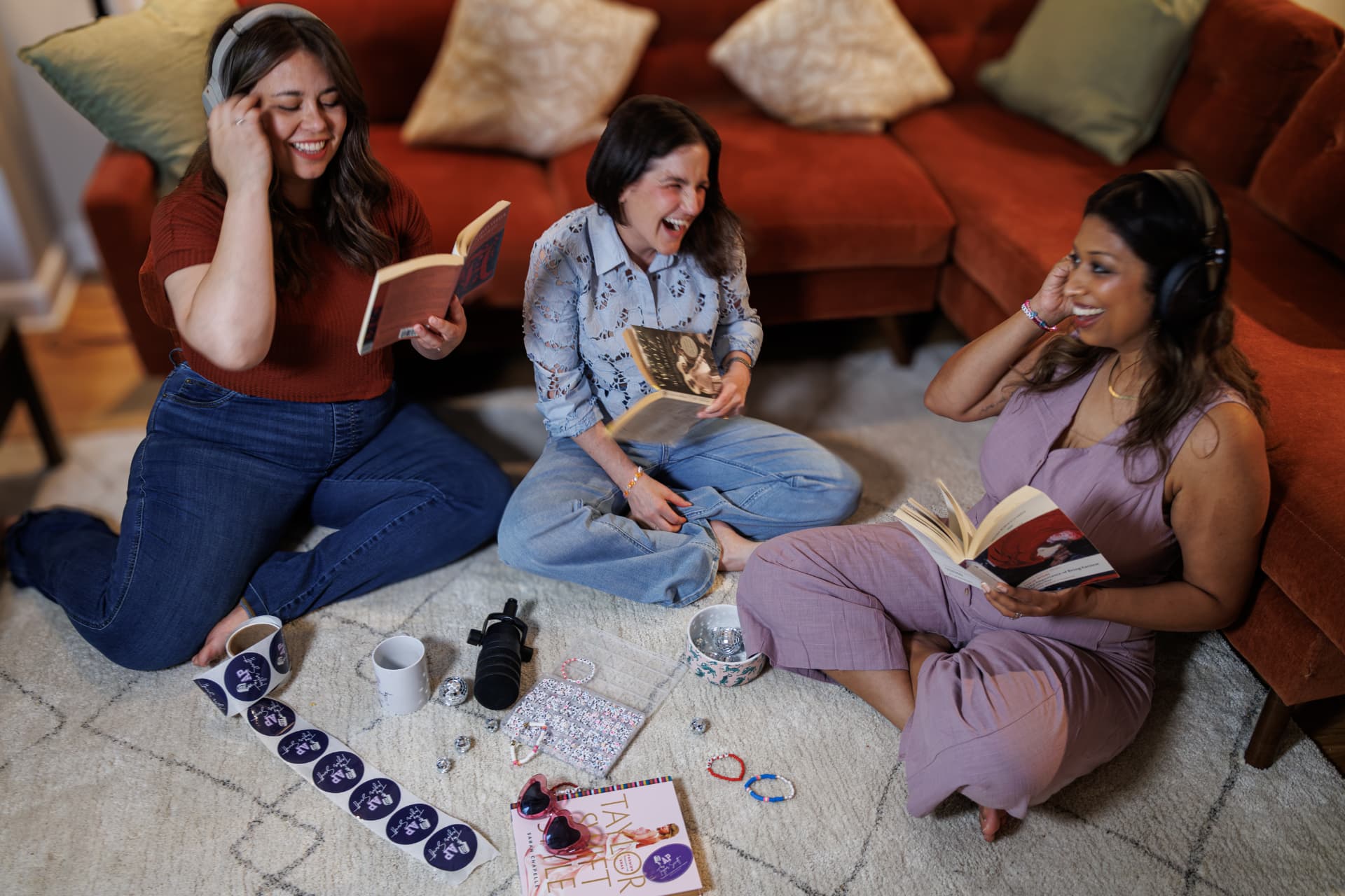 Jenn, Jodi and Maansi laughing together on the studio floor